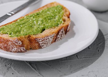 Bıçakla yayılmış ev yapımı pesto soslu ekmek.