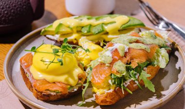 Toast and croissant with salmon, poached egg and avocado