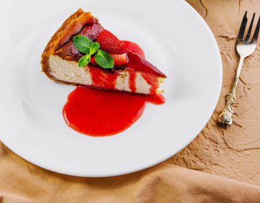 Çilek reçeli manzaralı cheesecake.