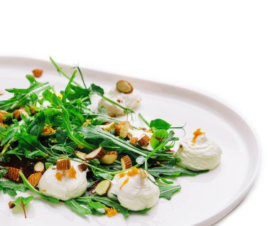 Çiğ badem dilimleri ve burrata peynirli Arugula salatası.