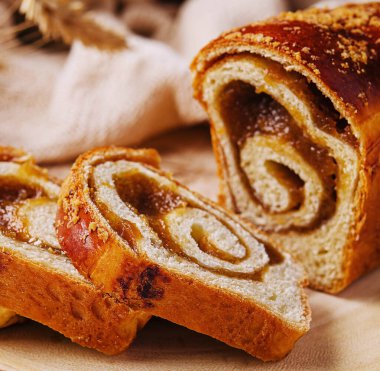 Tahtada elma reçeli ile dilimlenmiş büyük çörek.