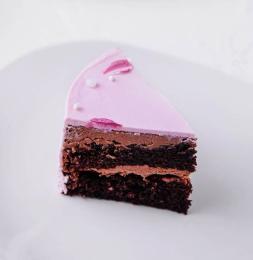 Piece of chocolate cake with pink cream