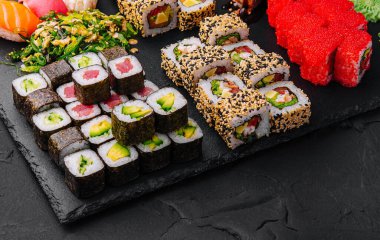 Sushi siyah taş arka planda ayarlandı