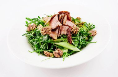 Warm salad of veal, arugula, cucumber with walnut