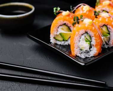 Siyah tabakta avokadosu olan Philadelphia Sushi.