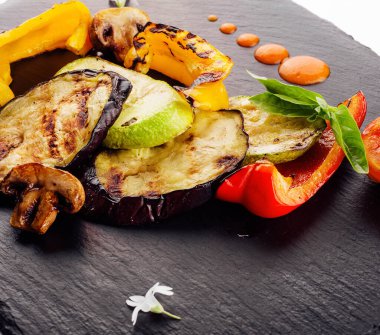 Koyu ahşap tahtada ızgara sebze çeşitleri.