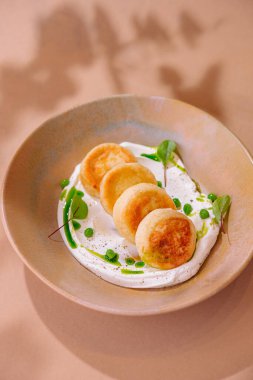 Taze otlarla süslenmiş beyaz soslu bir yatakta nefis mezeler süzme peynirli krepler.