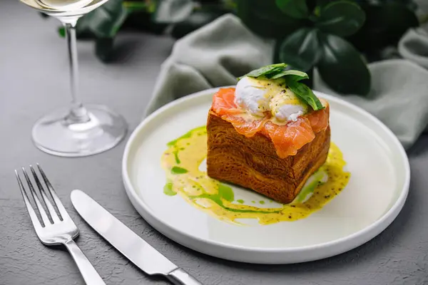 Elegant dish of smoked salmon on brioche with poached egg and basil, ready for a fine dining experience