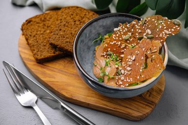 Zarif tavuk ciğeri servisi. Yanında tohumlar ve mikro yeşillikler. Yanında da siyah ekmek dilimleri.