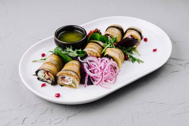 Lezzetli soslu patlıcan dürümleri ve taze süslemeler.