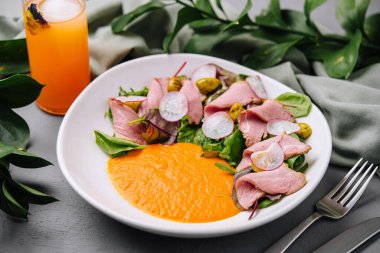 Renkli soslu canlı biftek salatası, ferahlatıcı portakal suyuyla servis edilir.