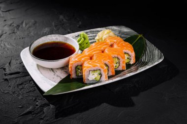 Soya soslu, wasabi ve zencefilli lezzetli somon suşi rulosu.