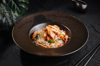 Lezzetli bir tabakta servis edilen kızarmış tavuklu pilav, gurme yemeği için mükemmel.