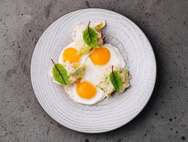 Çeşnili seramik tabakta taze otlarla haşlanmış yumurtaların zarif tabağı.