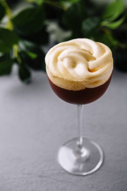 Nefis bir espresso martini kokteylinin yakın plan çekimi, kremalı, şık bir arka planda.