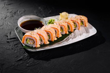 Somon, avokado ve krem peynirli iştah açıcı suşi, soya sosu, wasabi ve zencefil ile servis edilir.