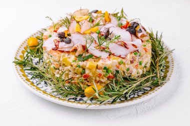 Geleneksel olivier salatası et dilimleri, otlar ve zeytinlerle süslenmiş, servis için hazır.