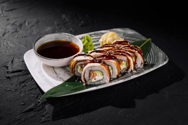 Susamlı ve soslu soya soslu lezzetli suşi rulosu.