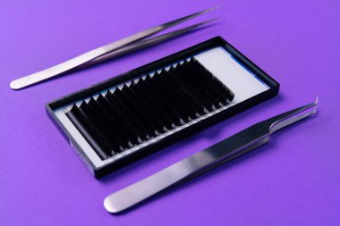 High-precision tweezers and eyelash strips for extensions, showcased on a vibrant purple surface clipart
