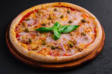 Koyu dokulu arka planda malzemelerle iştah açıcı pizza.