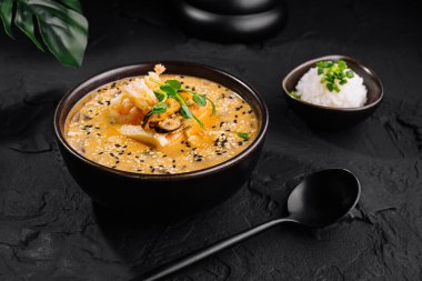 Appetizing kimchi stew served with rice on a dark, textured background clipart