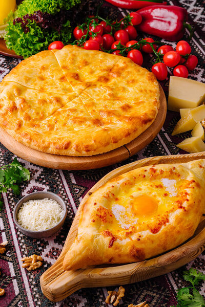 Sumptuous feast of adjarian khachapuri with egg and cheese pizza, surrounded by fresh ingredients