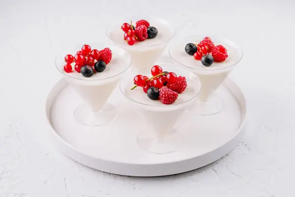 Элегантные Белые Десертные Чашки Сливками Увенчанные Яркими Красными Смородинами Черникой — стоковое фото