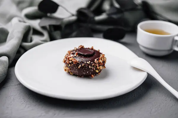 果仁巧克力一种用坚果装饰的美味巧克力 在灰色的背景下与茶一起食用 — 图库照片