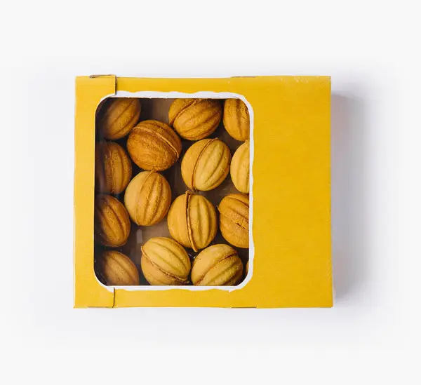顶部看到美味的自制坚果形状饼干在一个充满活力的黄色盒子 隔离在白色 — 图库照片