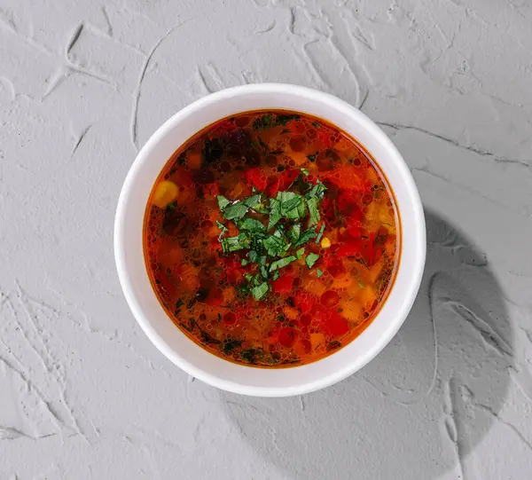 テクスチャの背景にチョップしたハーブで飾られた野菜スープのボウルのトップビュー — ストック写真