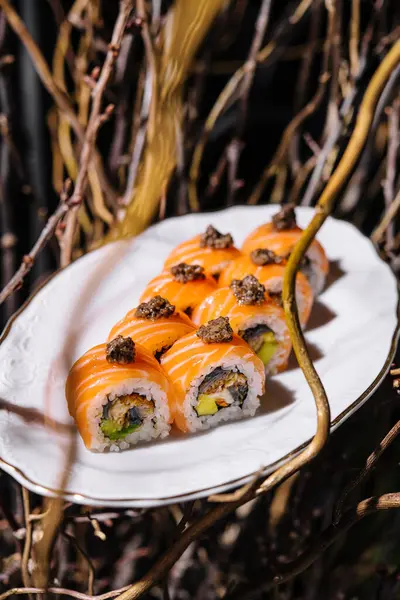 Exquisite salmon sushi roll topped with truffles, presented on a stylish white plate with artistic backdrop