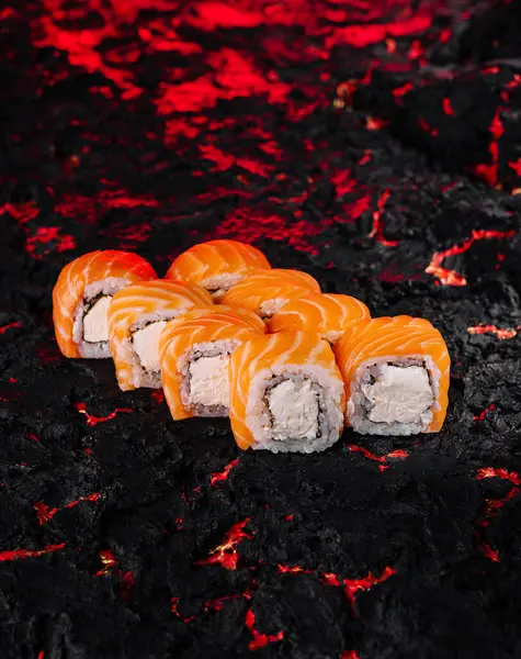 stock image Exquisite salmon sushi rolls artfully presented on a textured charcoal background