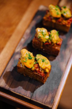 Kırsal ahşap bir tahtada servis edilen zarif küçük lokmalar, güzel yemek menüleri için mükemmel.