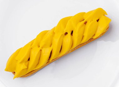 Beyaz arka planda izole edilmiş, saf, beyaz dairesel bir plaka üzerinde sunulan canlı mango ekini.