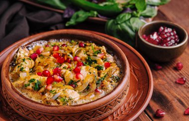 Karides, nar tohumu ve kırsal bir masada servis edilen taze otlarla iştah açıcı humus.