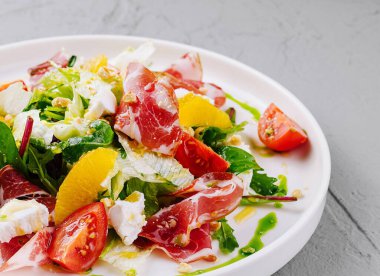 Jambonlu, portakallı, domatesli ve zeytinyağlı sağlıklı gurme salatası.