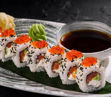 Havyarla kaplanmış nefis suşi ruloları soya sosu, wasabi ve zencefil ile servis ediliyor.