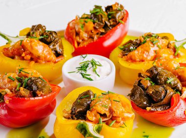 Vibrant dish of stuffed bell peppers with herbs and sauce, presented on a white background clipart