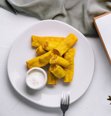 Soslu bir tabakta leziz böreklerin üst görüntüsü.