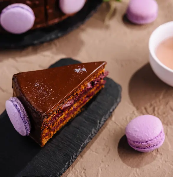 Кусок Богатого Шоколадного Слоя Торт Подается Фиолетовыми Макаронами Чай Элегантный Стоковая Картинка