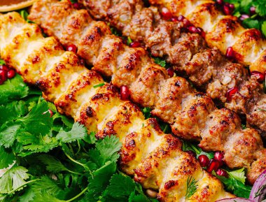 Soğan ve otlarla servis edilen baharatlı et şişleri. Kapatın.