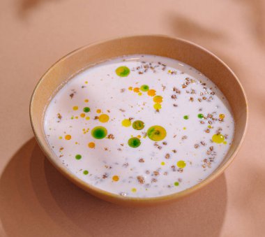 Canlı garnitürlü gurme çorbası. Pastel arka planda zarif bir şekilde servis edilir.