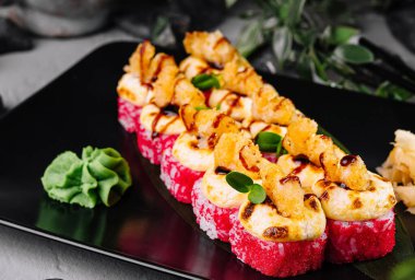 Enfes suşi tabağının taze malzemelerle sunumu. Deniz ürünleri. Ve suşi güzel bir restoranda yenir. Japon mutfağının aşçılık sanatını sergiliyorum. Zencefil