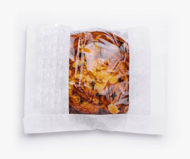 Şeffaf bir kruvasan içinde beyaz bir arka planda izole edilmiş lezzetli bir badem kruvasanın üst görüntüsü.