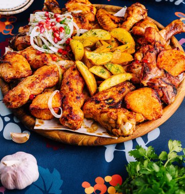 Canlı yayılmış kızarmış tavuk, altın patates ve taze sebzeler bayram masasında.