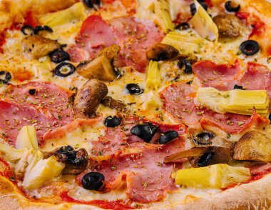 Çeşitli malzemelerle kaplanmış taze pişmiş en iyi pizza.