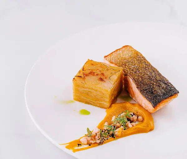 stock image Exquisite plated salmon dish with crispy skin and puree, ready for fine dining