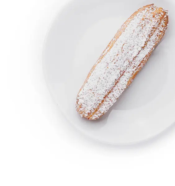 İştah açıcı, toz şekerle kaplanmış, el değmemiş beyaz bir tabakta servis edilmiş.