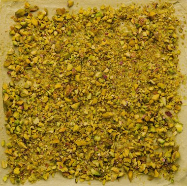 Üzerinde ezilmiş şam fıstığı serpiştirilmiş geleneksel baklava tatlısı var.