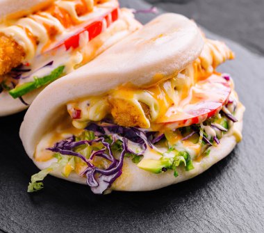 Lezzetli tavuklu bao çörekleri tabakta servis edilir, modern Asya mutfağı menüleri için mükemmeldir.